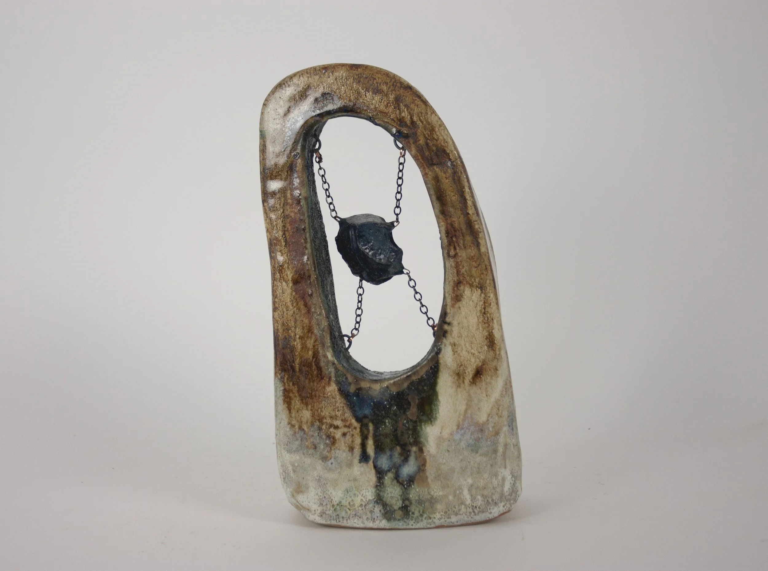 "Slag," 2023. Slag glass from the National Building Arts Center in Sauget, IL, chain, crushed steel glaze, ceramic, apoxie clay. 8 x 4.5 x 1.5 inches.
