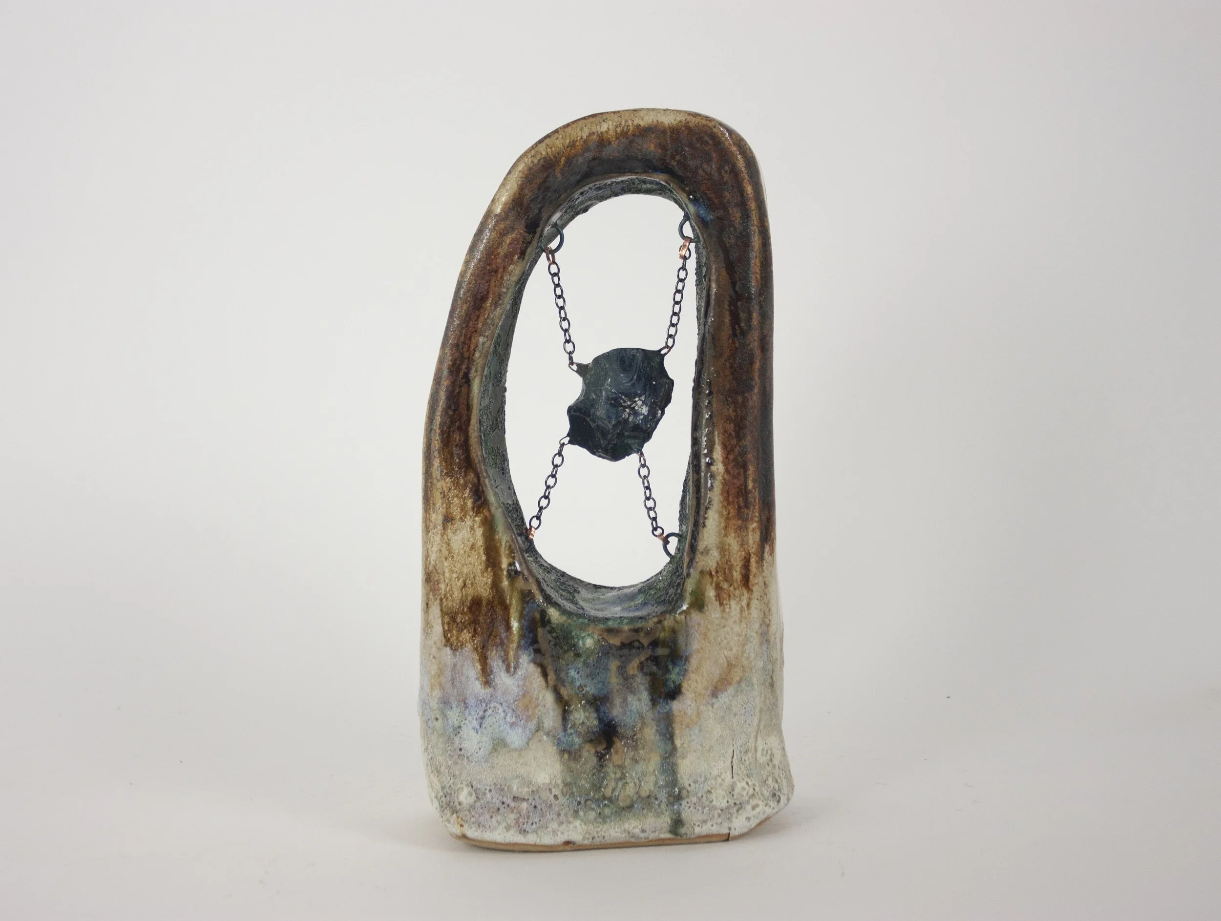 "Slag," 2023. Slag glass from the National Building Arts Center in Sauget, IL, chain, crushed steel glaze, ceramic, apoxie clay. 8 x 4.5 x 1.5 inches.