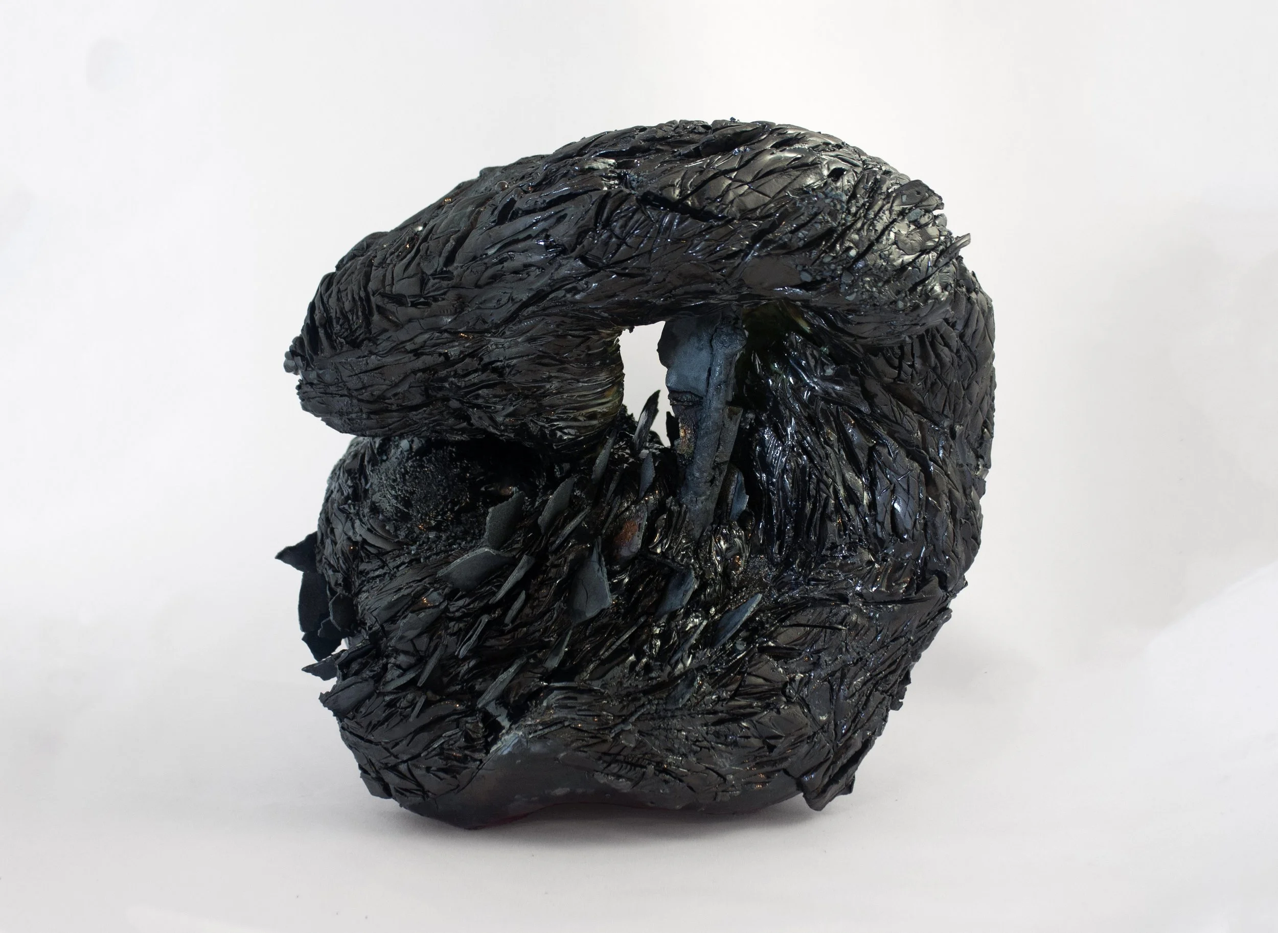 "Nucleus," 2023. Steel fragments, serrated black stoneware, crushed steel glaze.