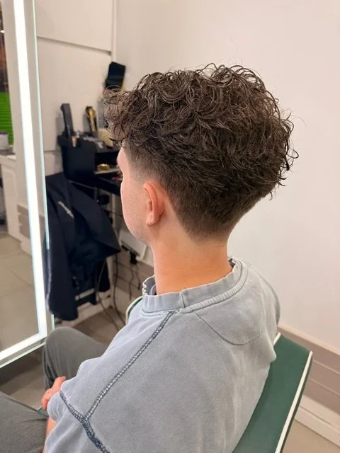 Men’s curly haircut with tapered fade at a Boston hair salon