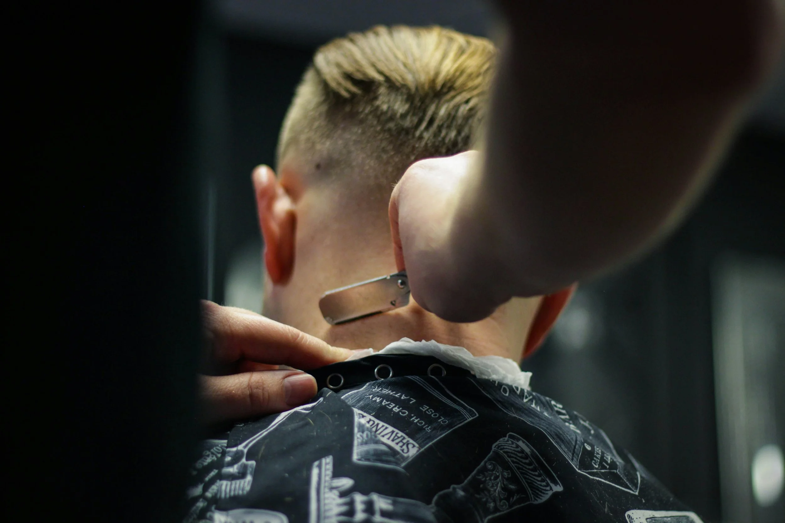 A professional barber performing a precision fade haircut at Street Salon Back Bay in Boston.