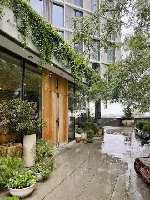 Main entrance to the 1 West Hollywood Hotel. A large wooden door with surrounding vines and greenery.