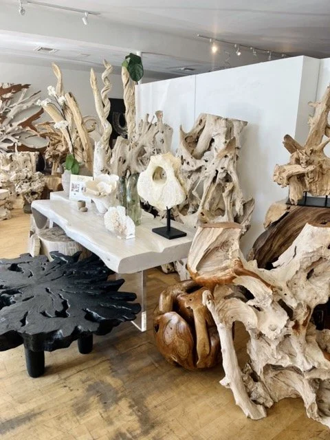 Teak root tables and other natural wood art pieces are displayed at DOA.