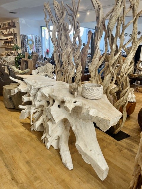 Teak root tables and other natural wood art pieces are displayed at DOA.