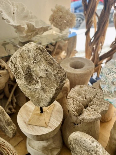 Teak root tables and other natural wood art pieces are displayed at DOA.