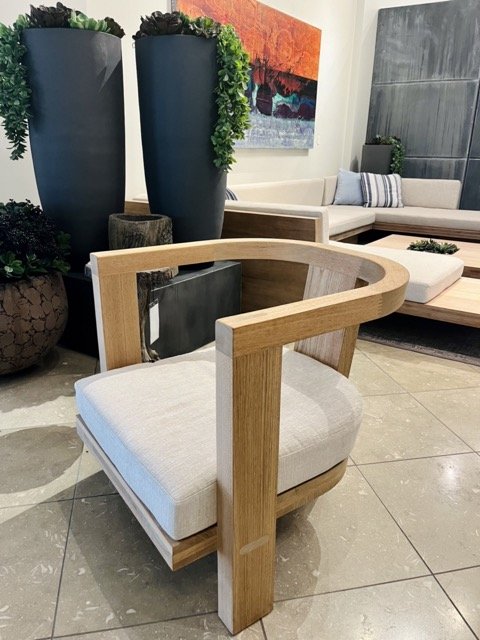 A wooden outdoor chair with a white seat cushion at the Perennials and Sutherland showroom in the West Hollywood Design District.