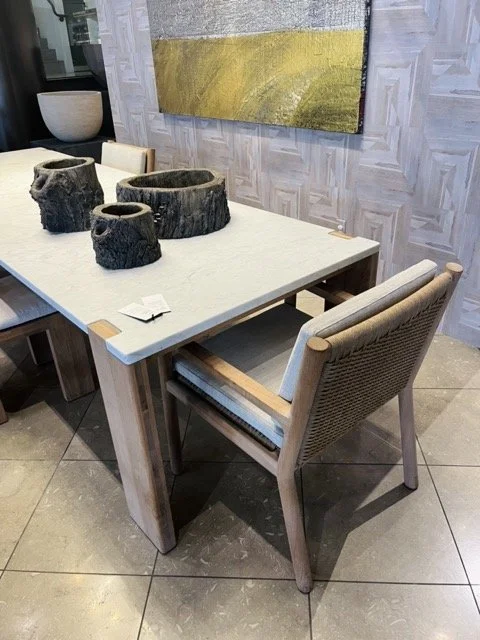 An outdoor table and chair with decorative wooden bowls on the table at the Perennials and Sutherland in West Hollywood Design District.