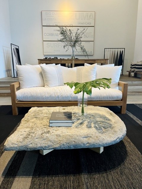 A modern, white couch sits in front of a stone table at the James Perse showroom in the West Hollywood Design District.