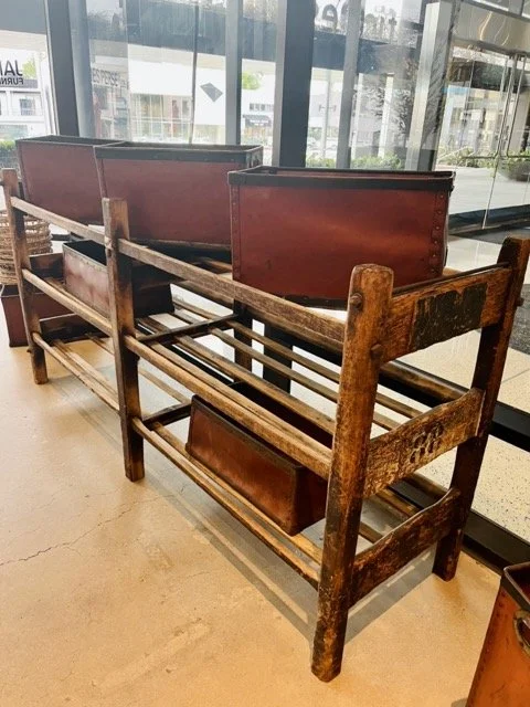 Open, wooden shelving with red baskets sitting on top at the James Perse showroom.