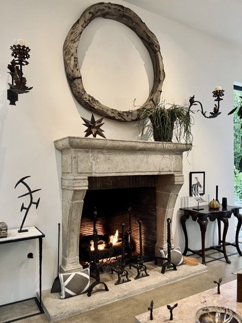 A stone hearth surrounds a fireplace with decorative items surrounding at Formations in West Hollywood.