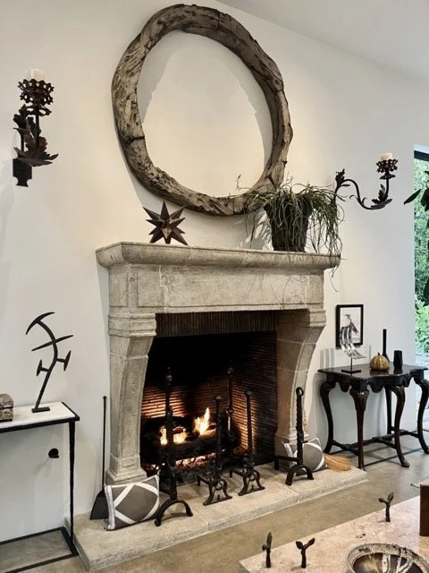 A stone hearth surrounds a fireplace with decorative items surrounding at Formations in West Hollywood.