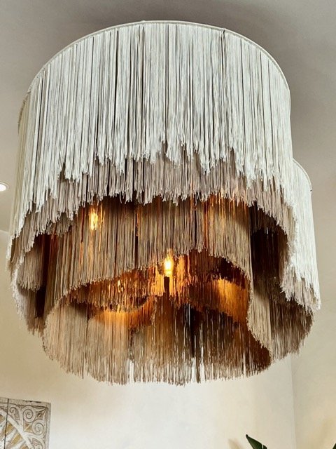 A chandelier with rope-like materials hanging all around in layers at West Hollywood Design District.