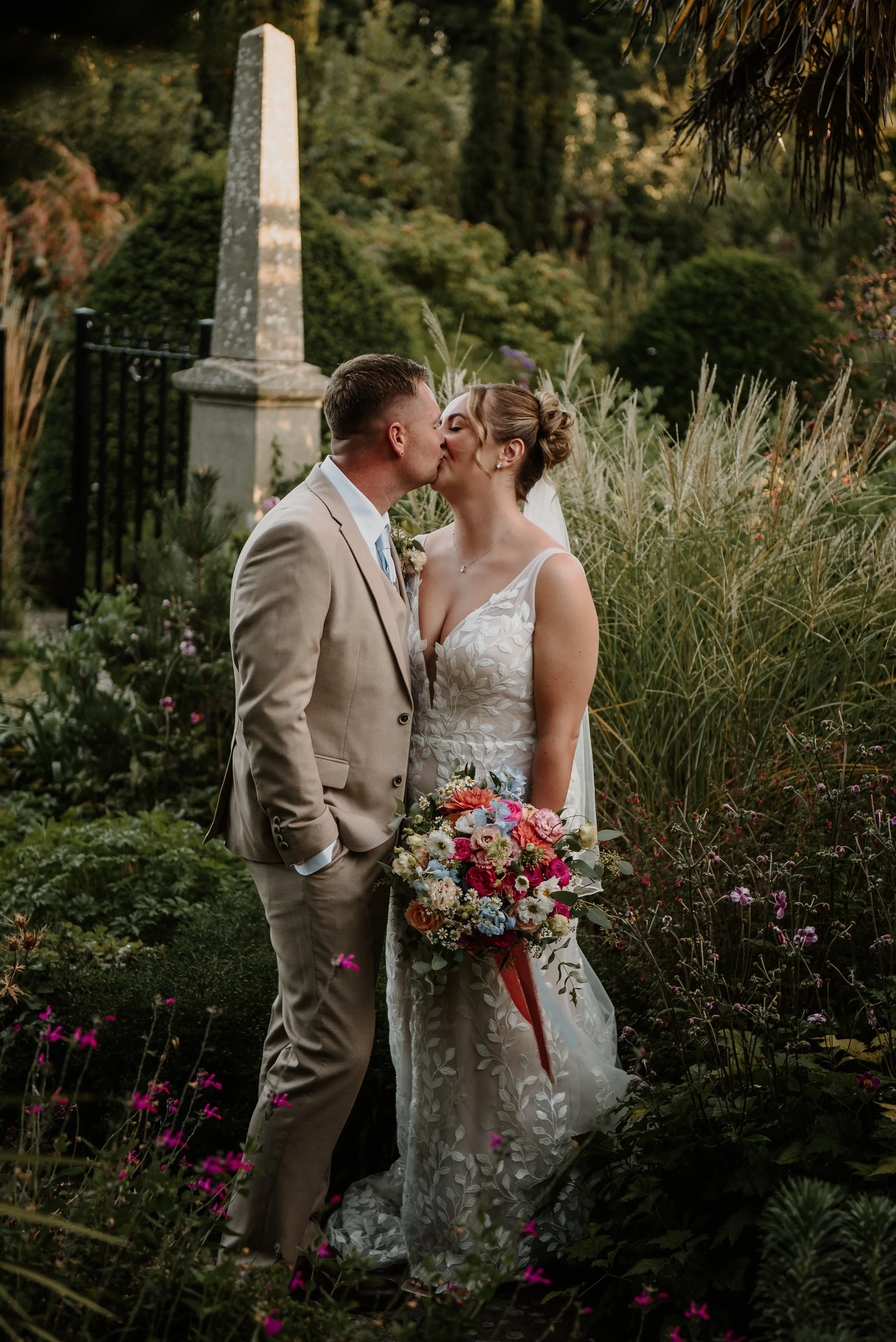 Bride and groom kissing in the gardens at Chapel House