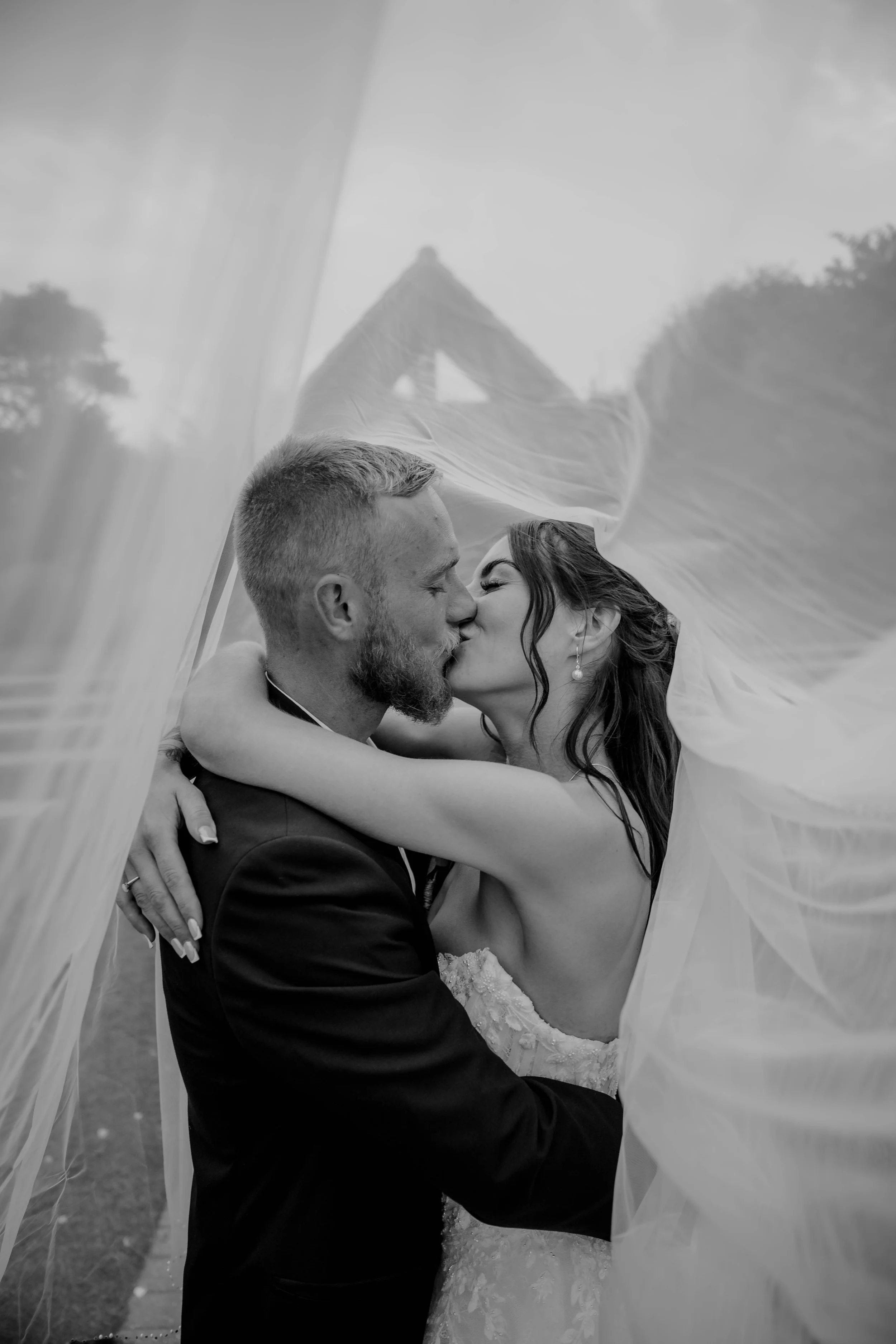 bride and groom kissing under the veil at Reach Court Farm