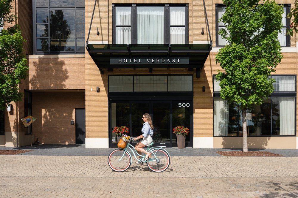 Hotel Verdant entrance with cyclists passing the property