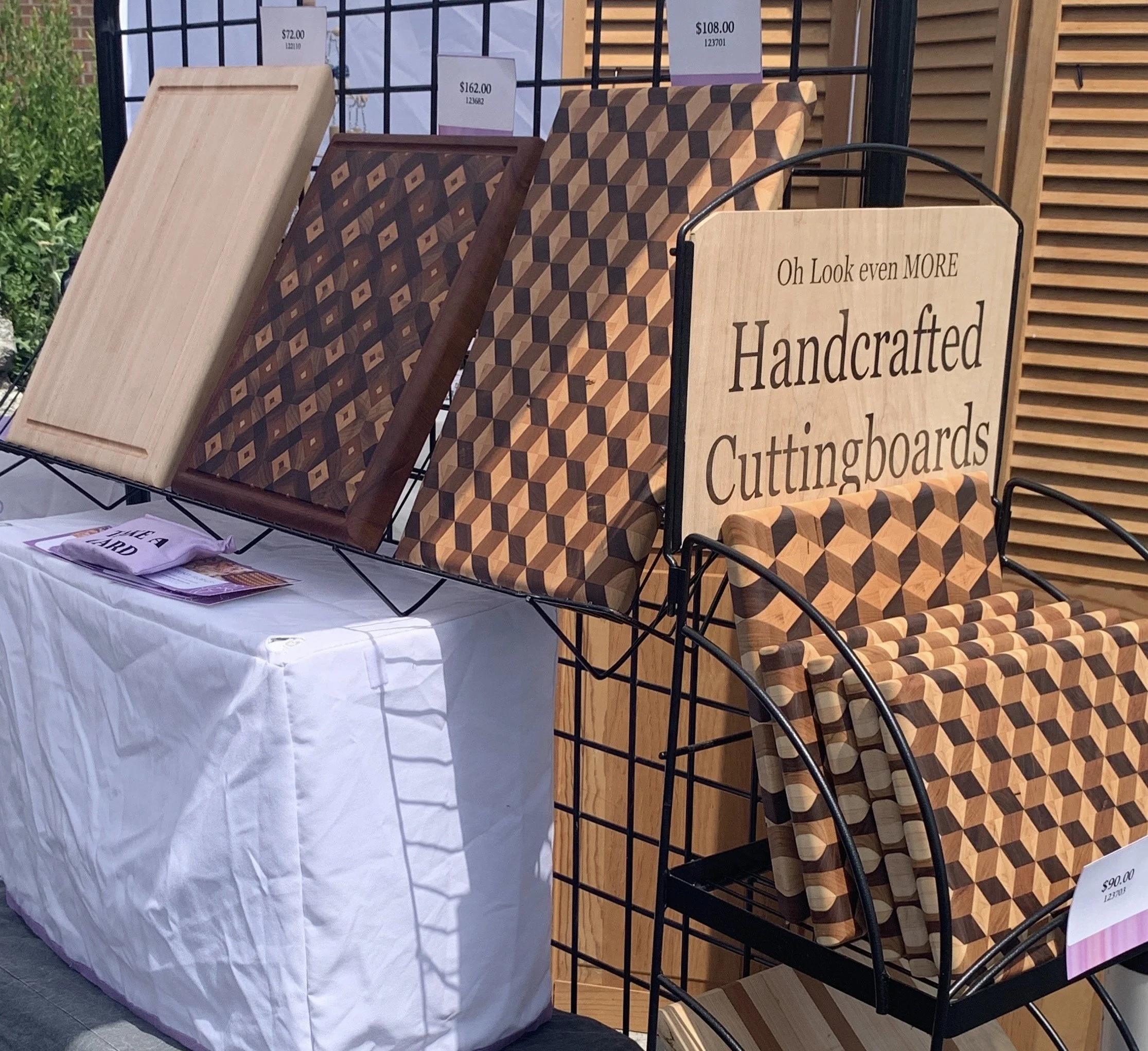 wooden cutting boards on display at a vendor market