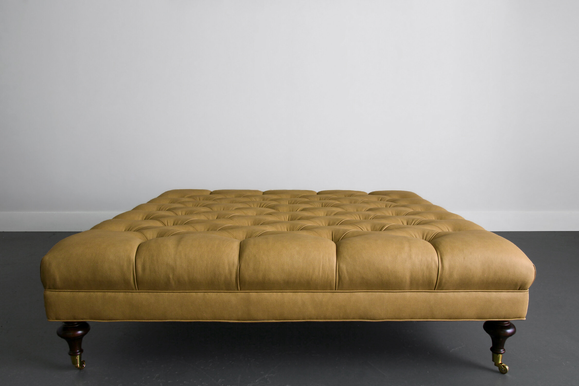 Custom Leather Tufted Ottoman with Turned Wooden Legs on Brass Casters