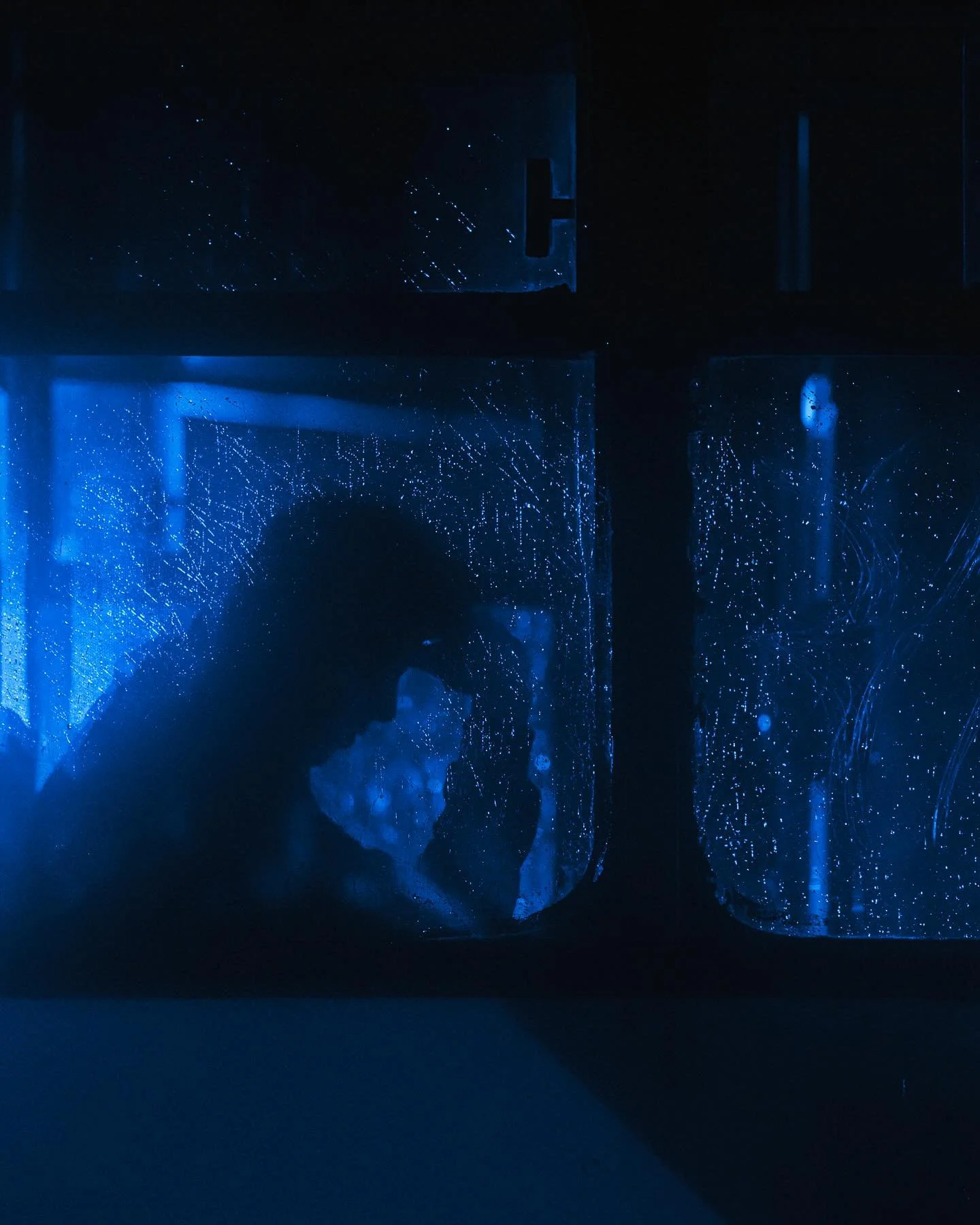 &ldquo;Layers of Cobalt Blue&rdquo;

A rain-soaked night on a dimly lit bus. The glow of my phone, the only light. Outside, the city blurs into layers of raindrops and neon lights. Through the foggy window, I see her silhouette, head resting on her h