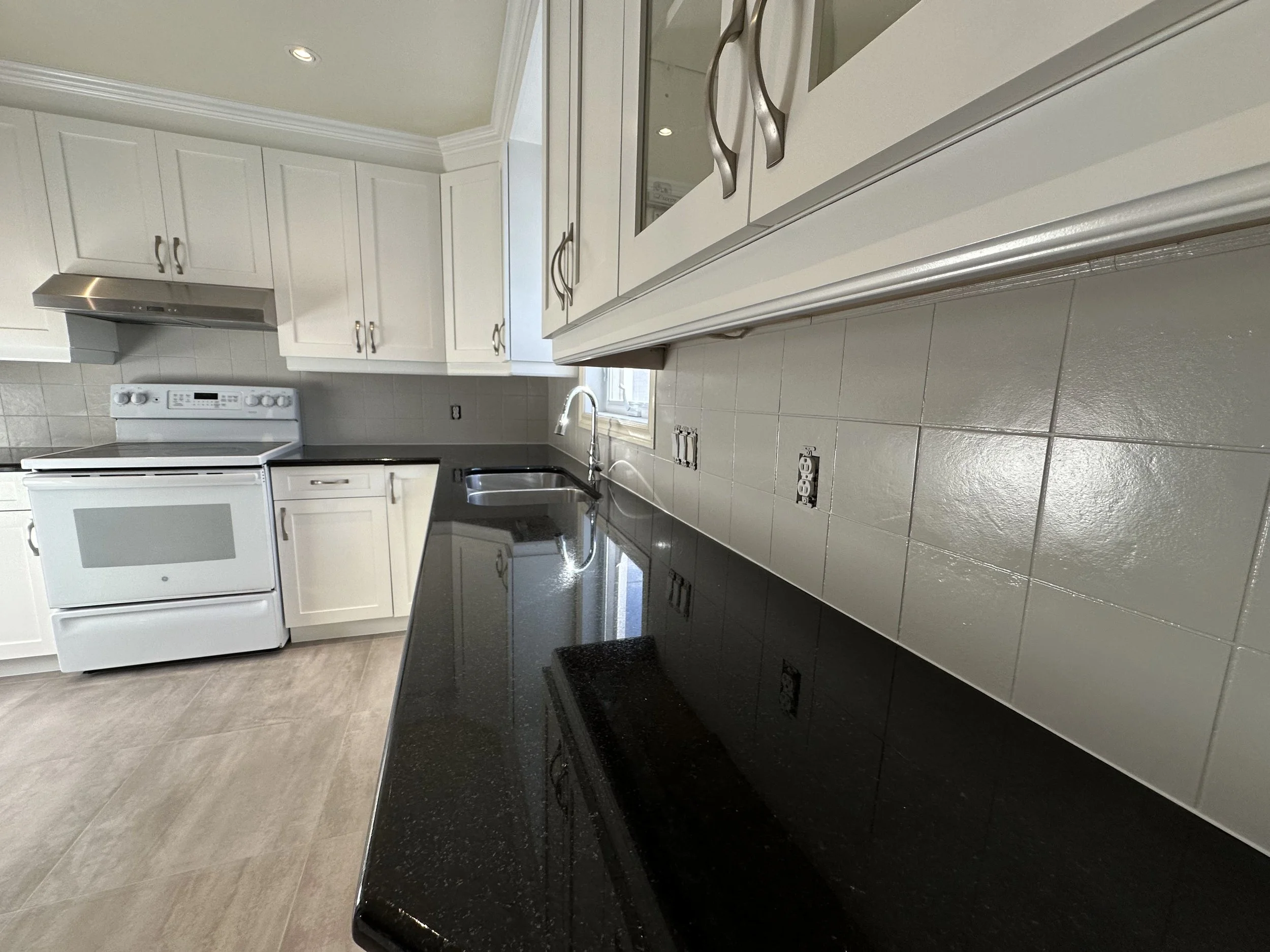 Armoires de cuisine rénovées grâce au resurfaçage sur la Rive-Sud. cuisine 2 couleurs avec dosseret repeint