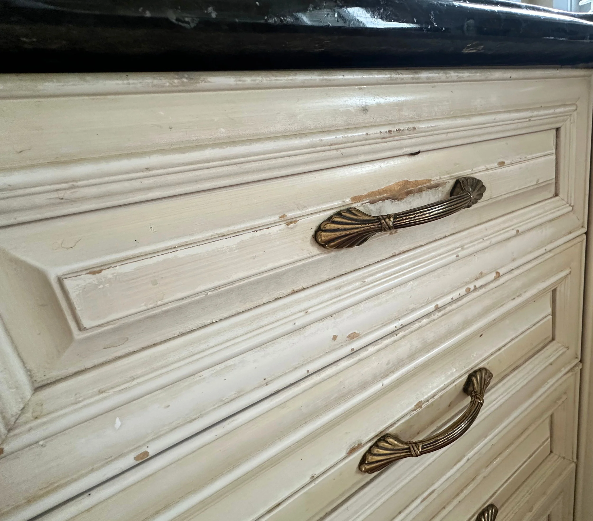 Façade de tiroir en MDF avec pellicule de finition sévèrement endommagée quelques années après un refacing