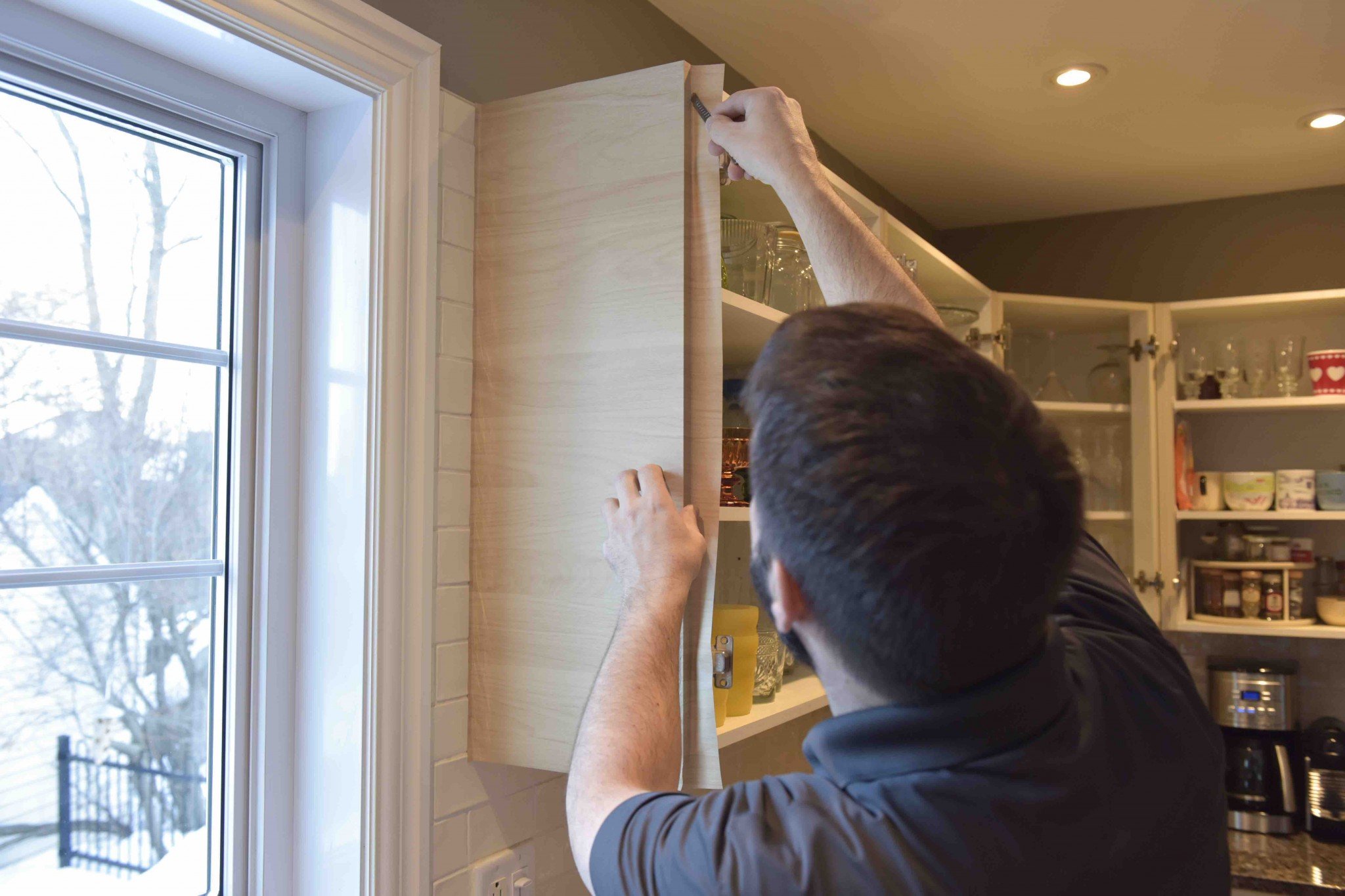 installation d'un vinyle sur ses armoires de cuisine.