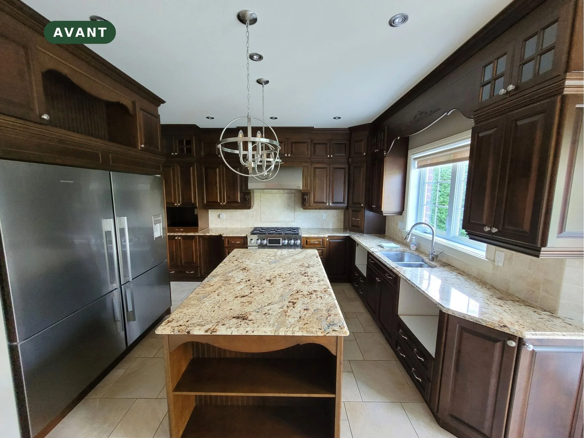 Avant : grande cuisine en merisier teint foncé avec îlot à Blainville, sur la Rive-Nord de Montréal