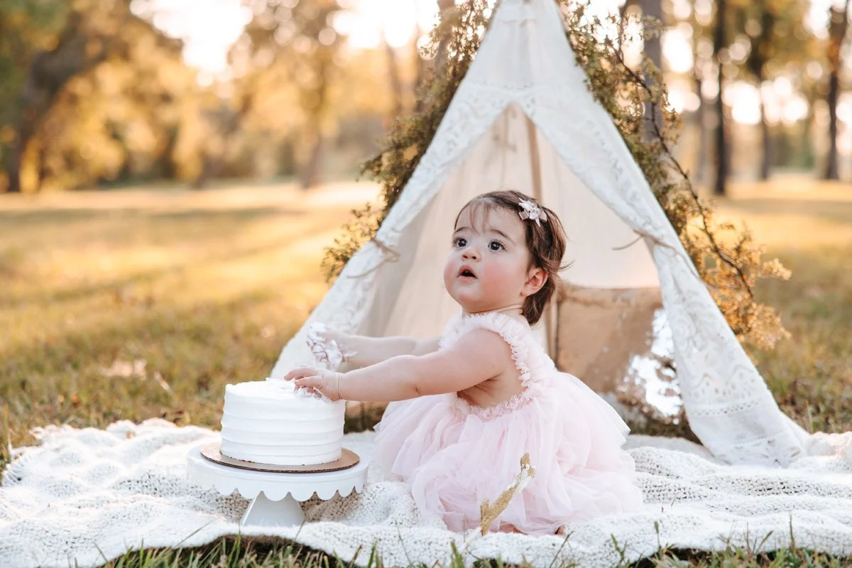 Baby girl sunset photos eating cake with lace teepee