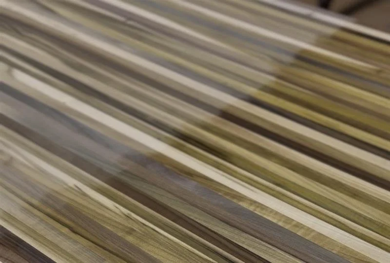 Rainbow poplar sample showing raw wood and clear coat finish comparison.