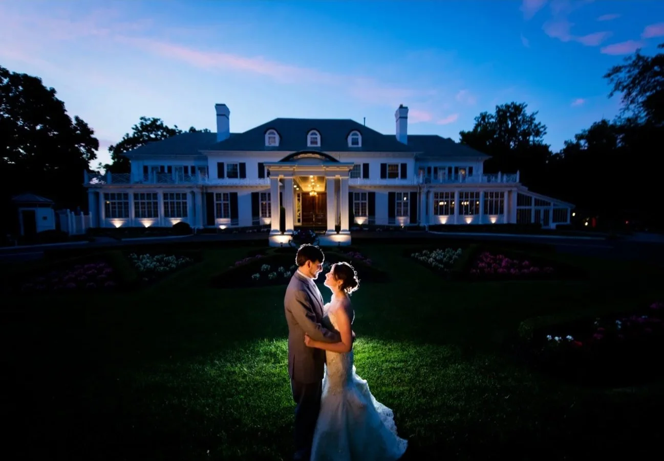 Wedding couple outside the illuminated Shadowbrook estate at dusk