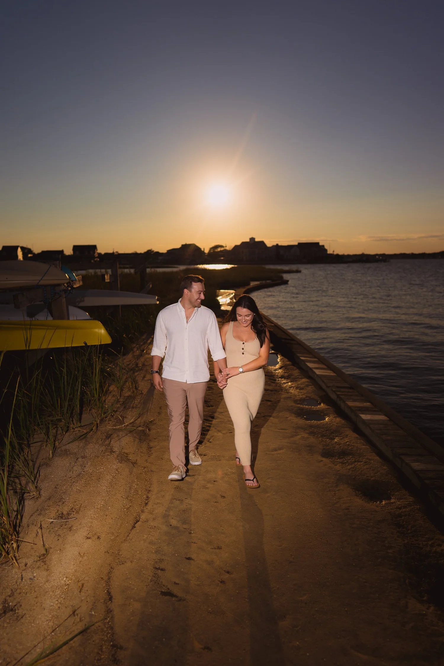 Couple walking together by the water at sunset