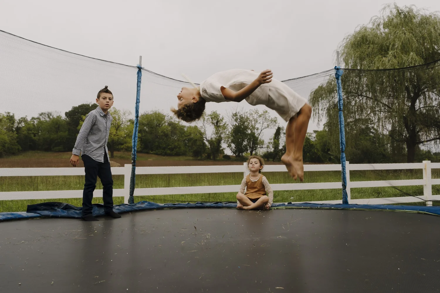 A child airborne above the trampoline while other children watch