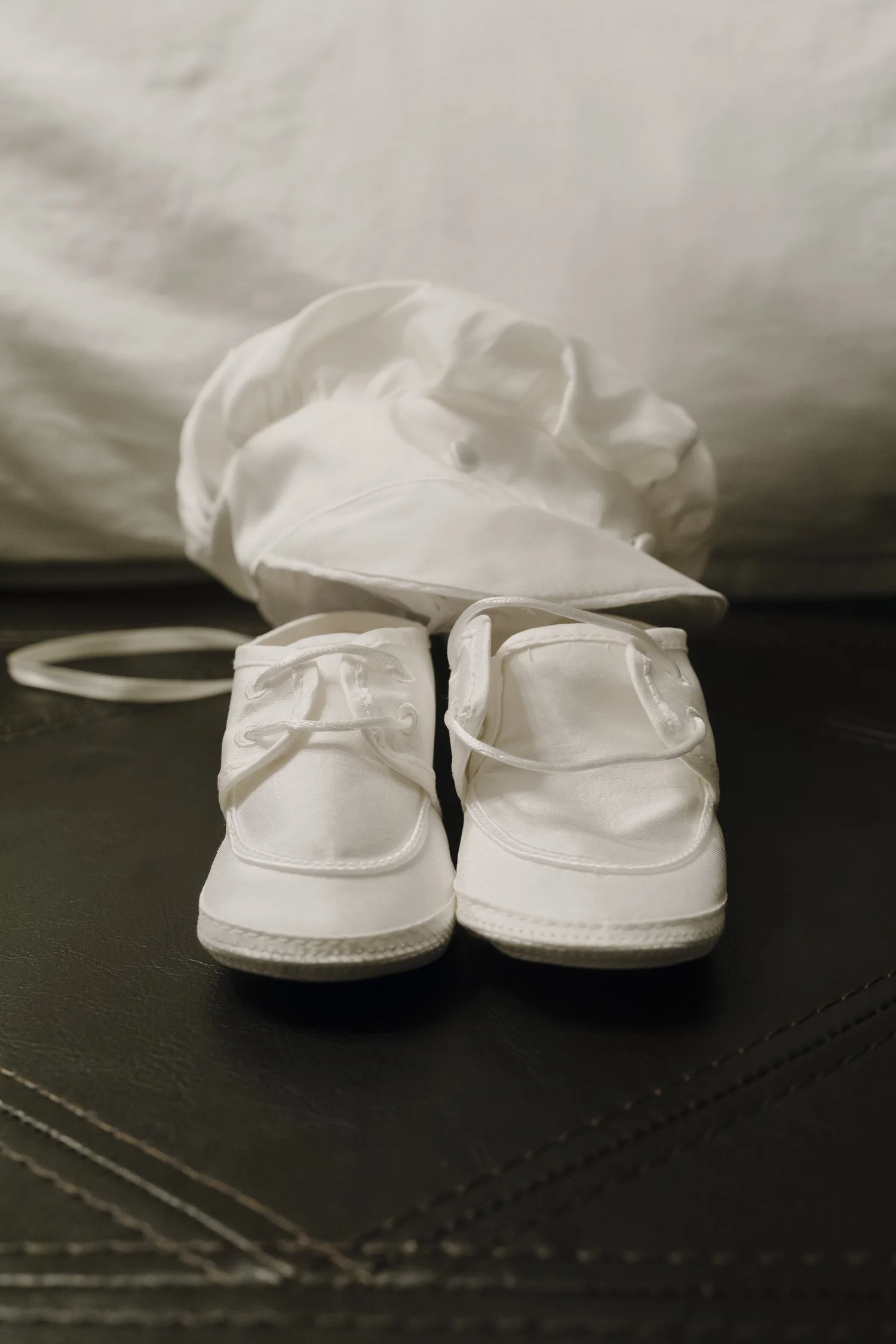 Gabriele’s tiny white shoes with his baptism outfit