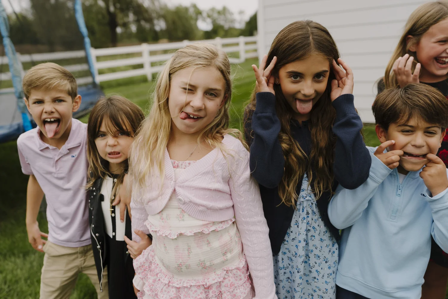 Children making playful faces together during the party