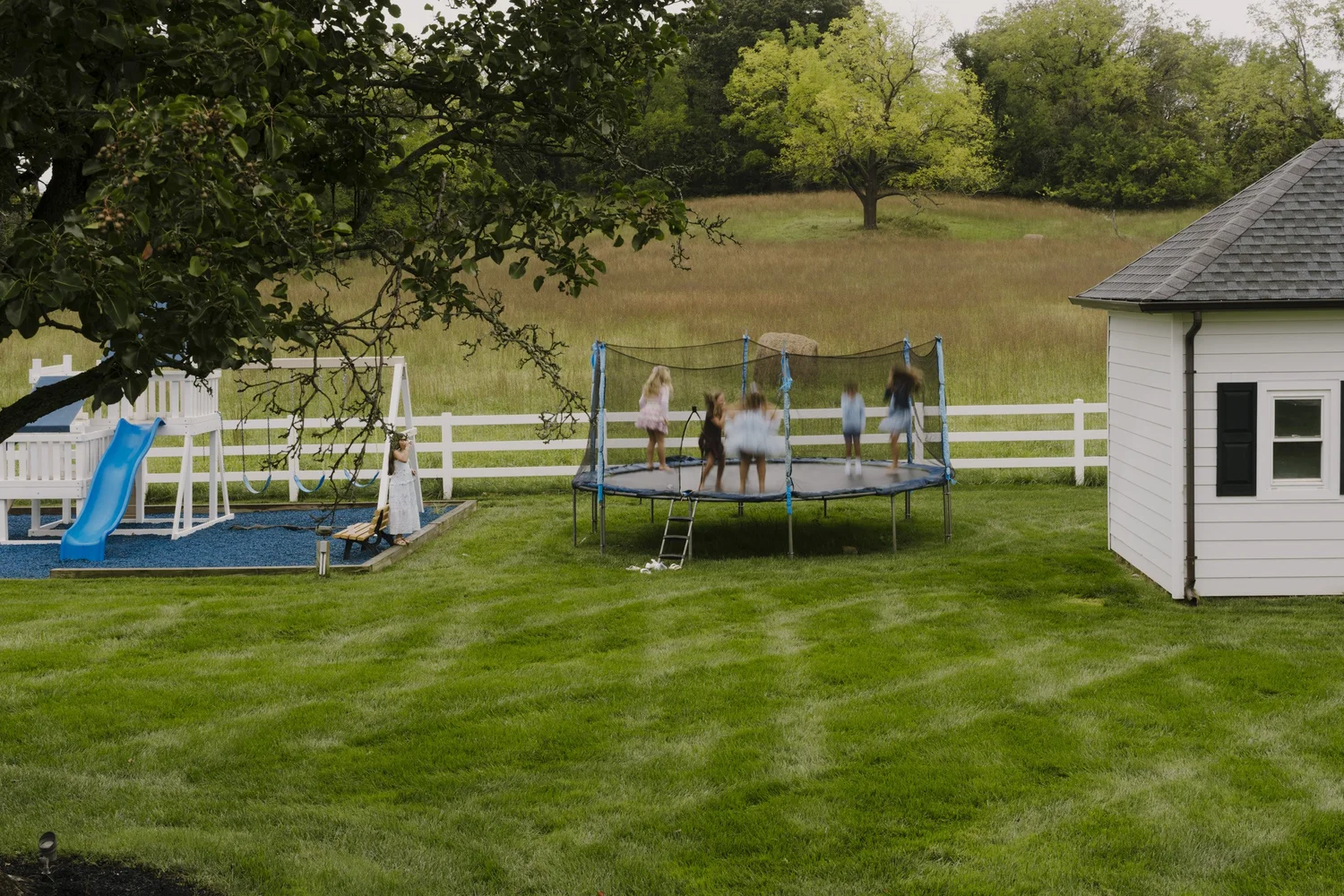 Children bouncing on the backyard trampoline during the celebration in Holmdel