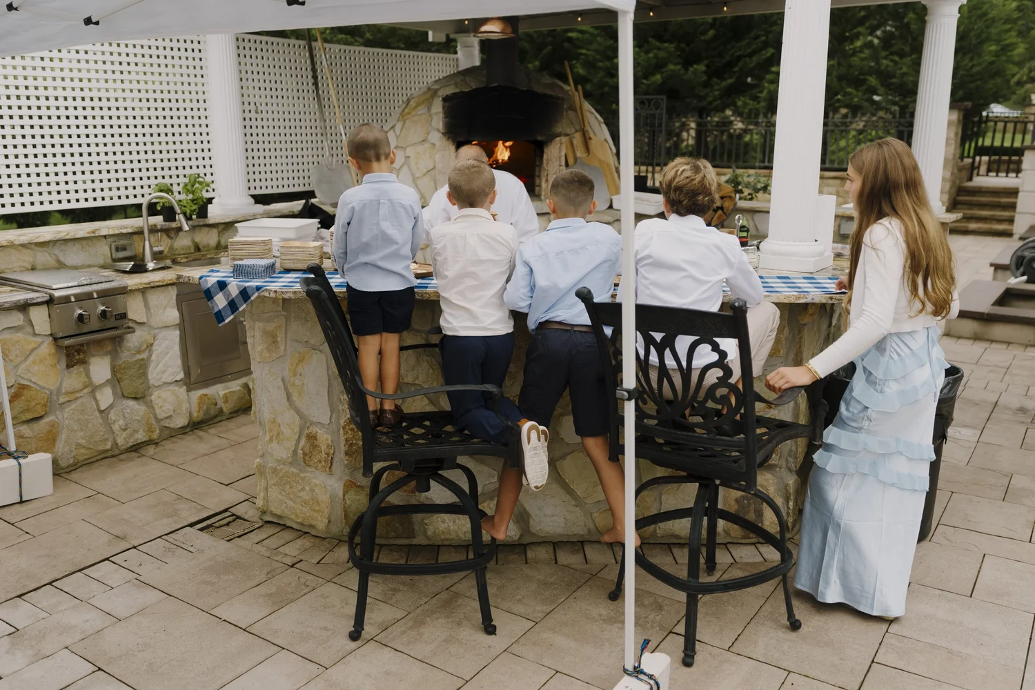Children gathered by the outdoor cooking area during the celebration at home