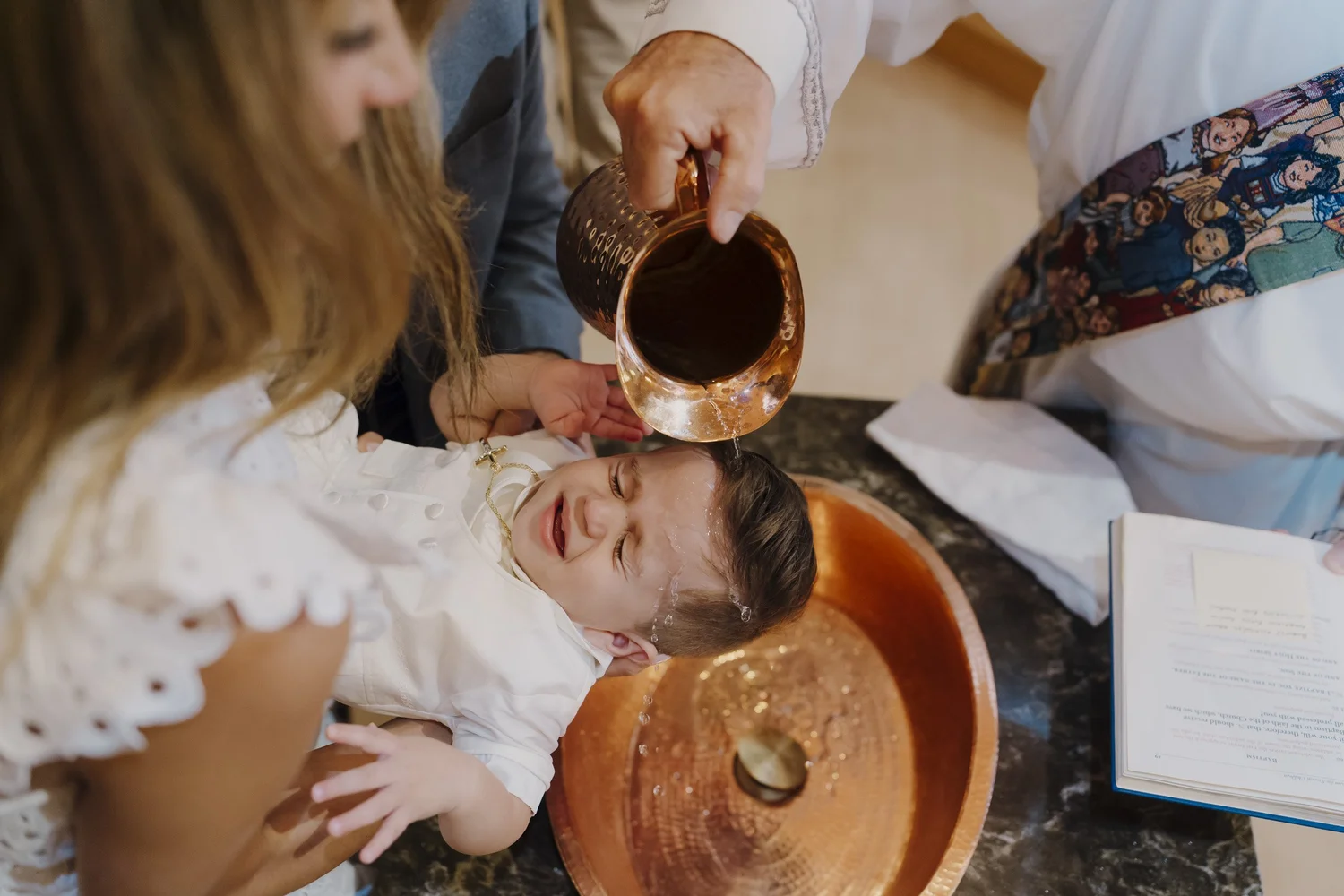 Water poured over Gabriele’s head during his baptism at Saint Leo’s Church in Lincroft