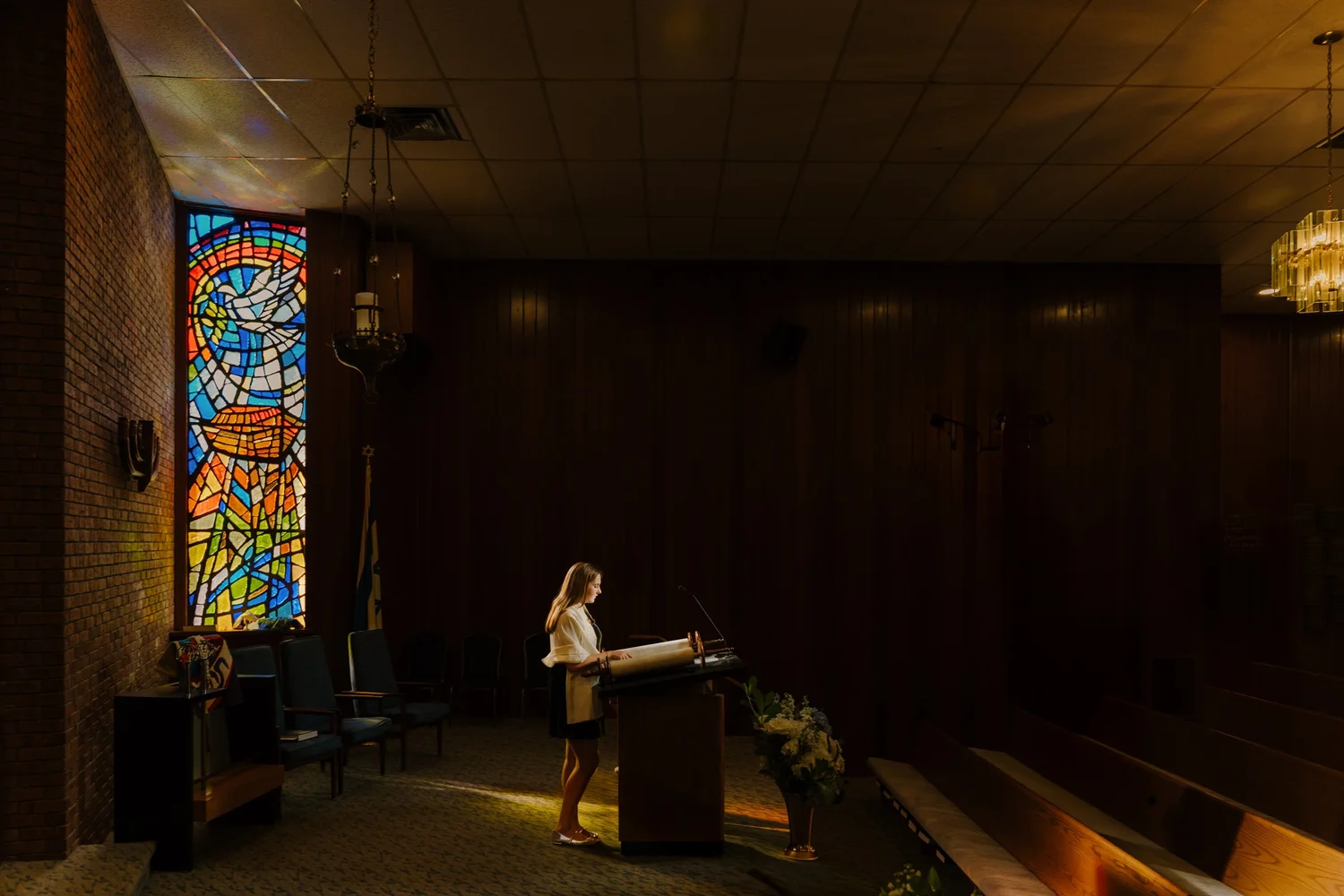 Young woman reading from a prayer book at a mitzvah