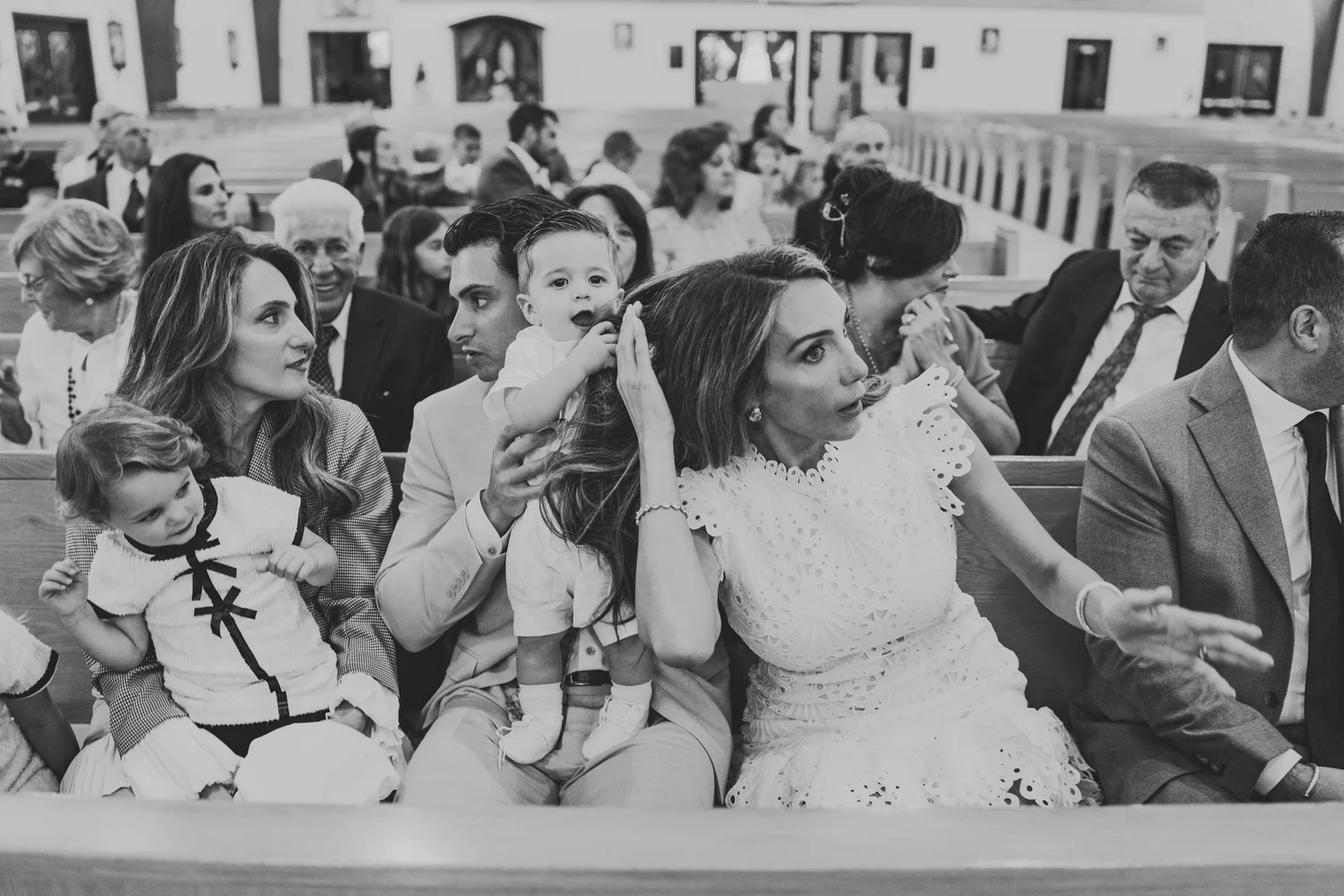 Black and white photograph of loved ones seated in the church pews