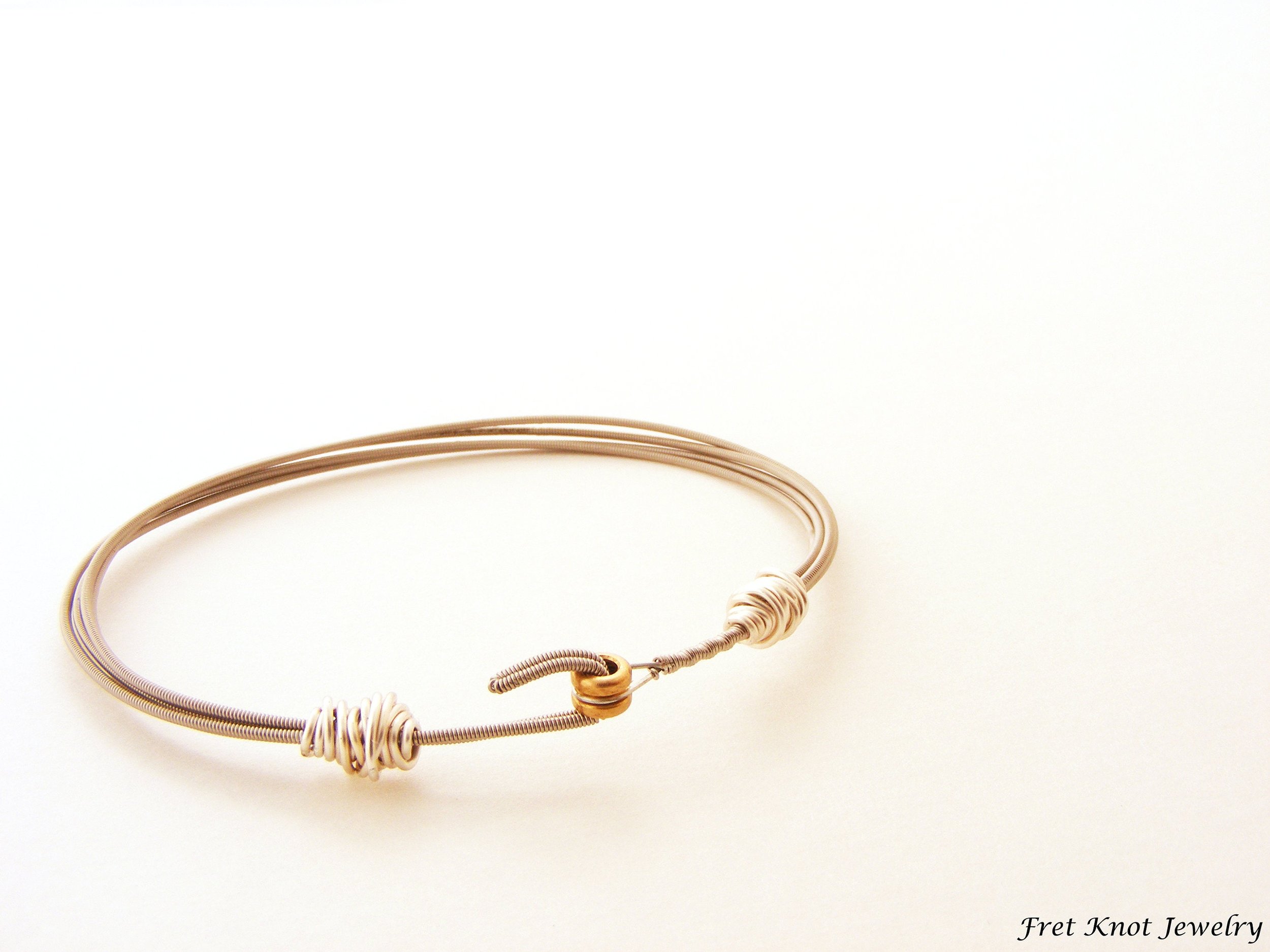 Guitar string bracelet with silver tone wave bead