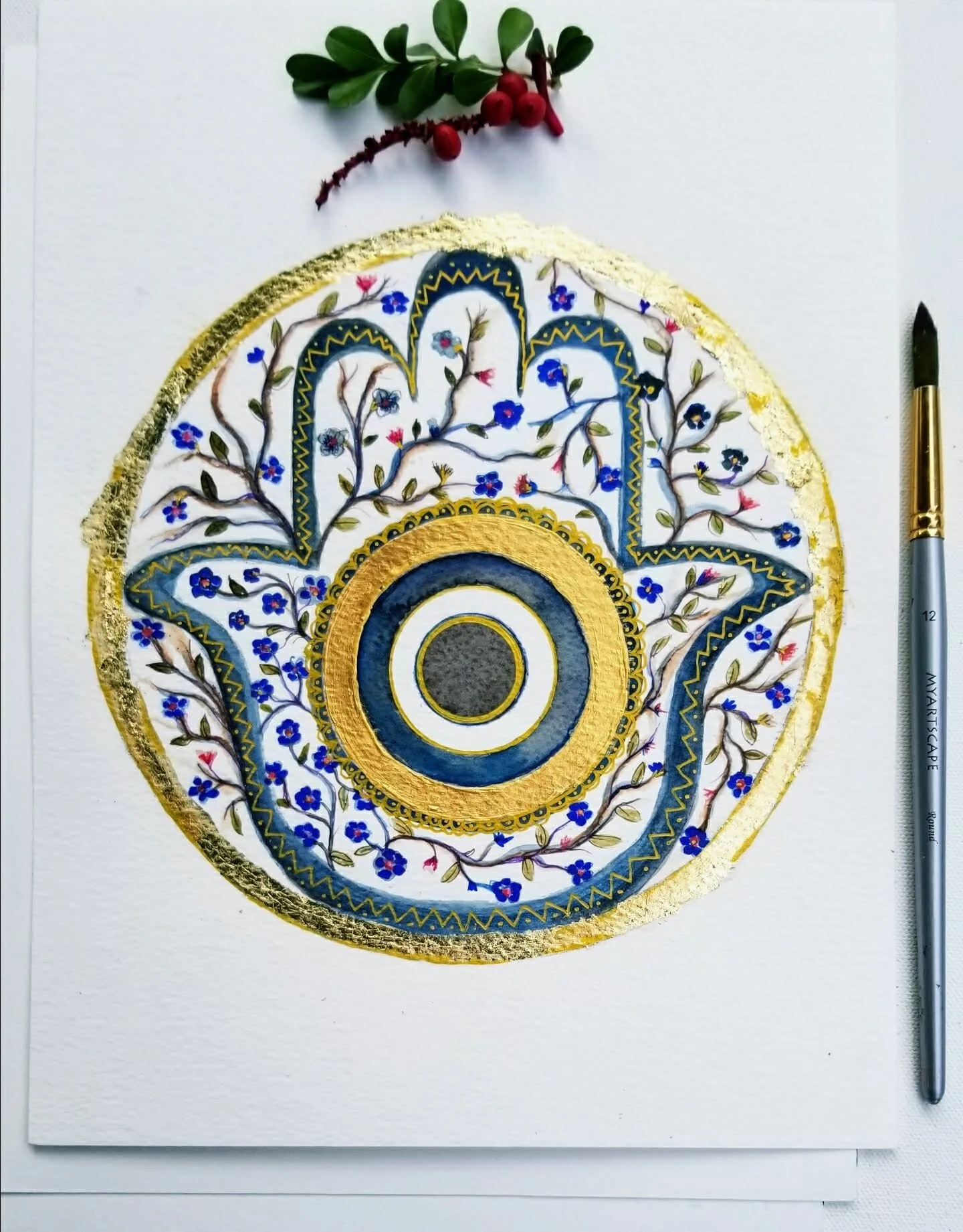 a watercolor floral golden hamsa in circular mandala with evil eye