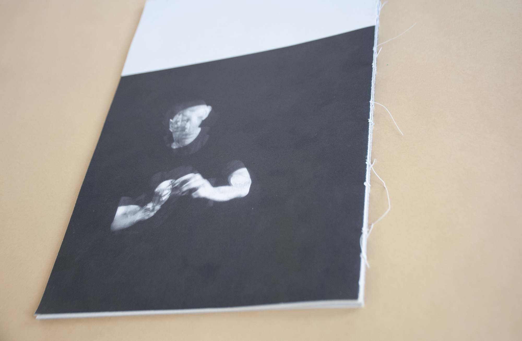 A farther shot of the catalogue shows the man in black background portrayed in a double image or in a motion picture.