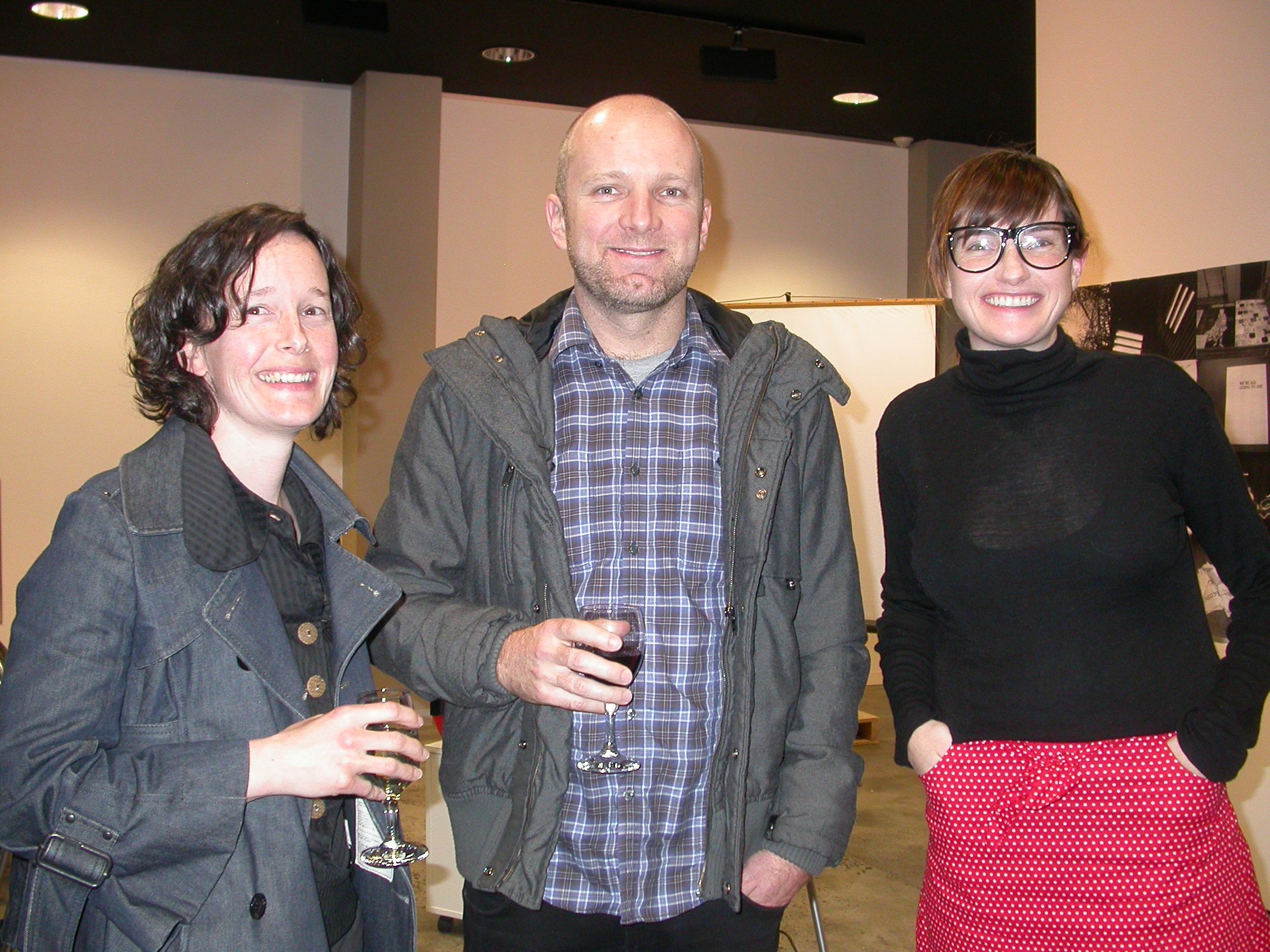 Two women and a man smiling for the camera.