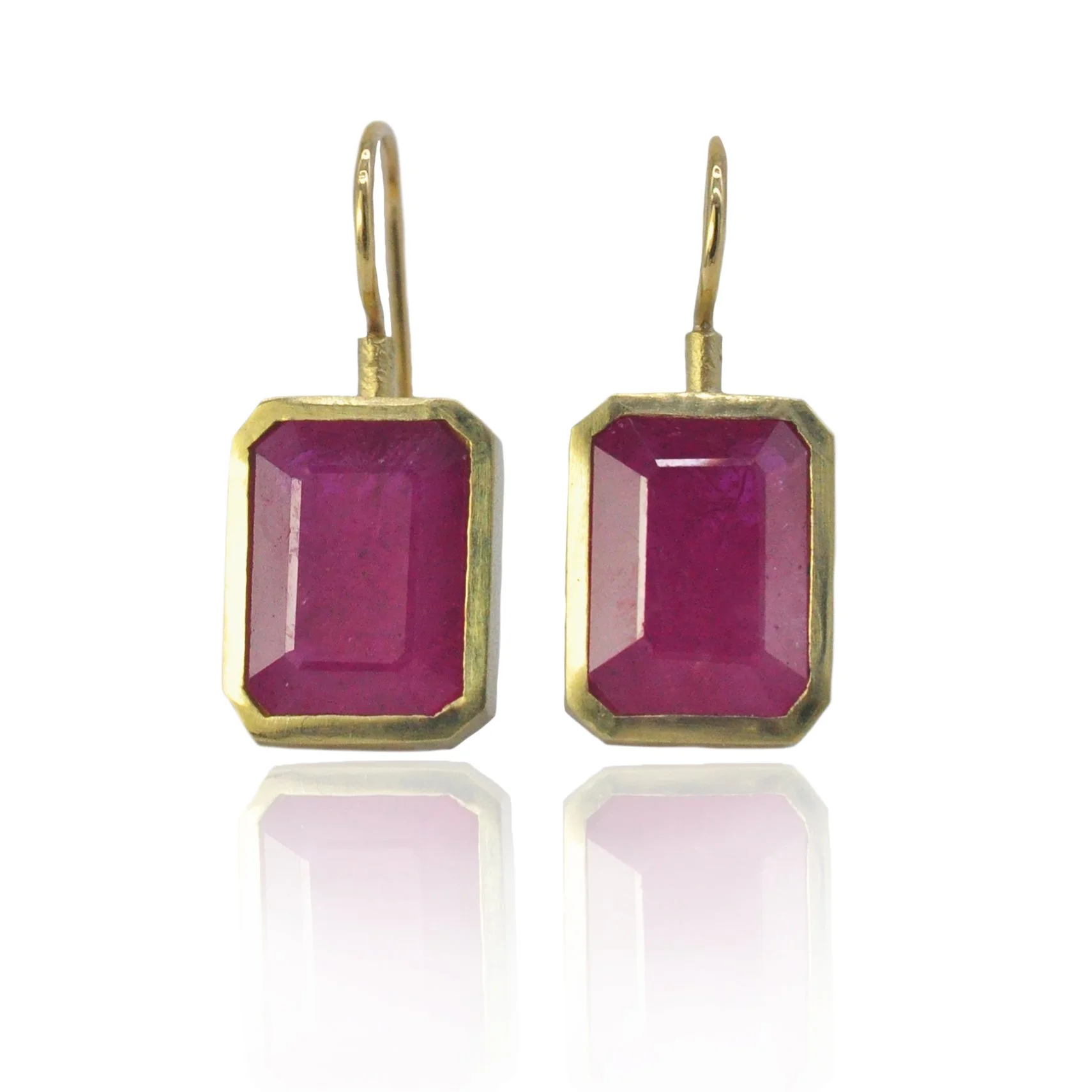 A pair of dark pink emerald cut ruby earrings in 18k yellow gold bezel settings | Simple gold ruby drop earrings by Rebecca Myers Design