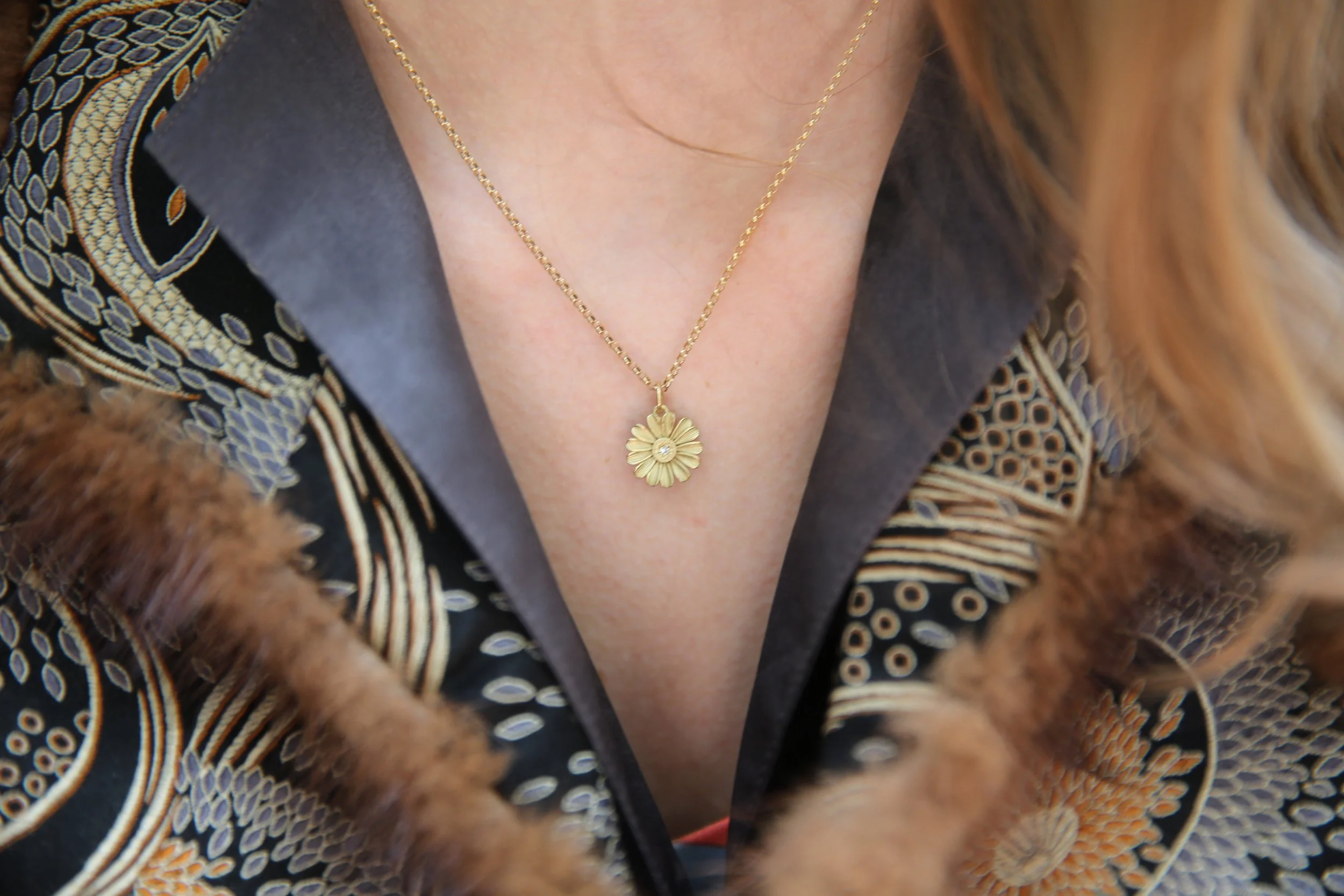 Gold & Diamond Shasta Daisy necklace in 18k yellow gold modeled on white woman. Handmade fine art jewelry by Rebecca Myers Design.