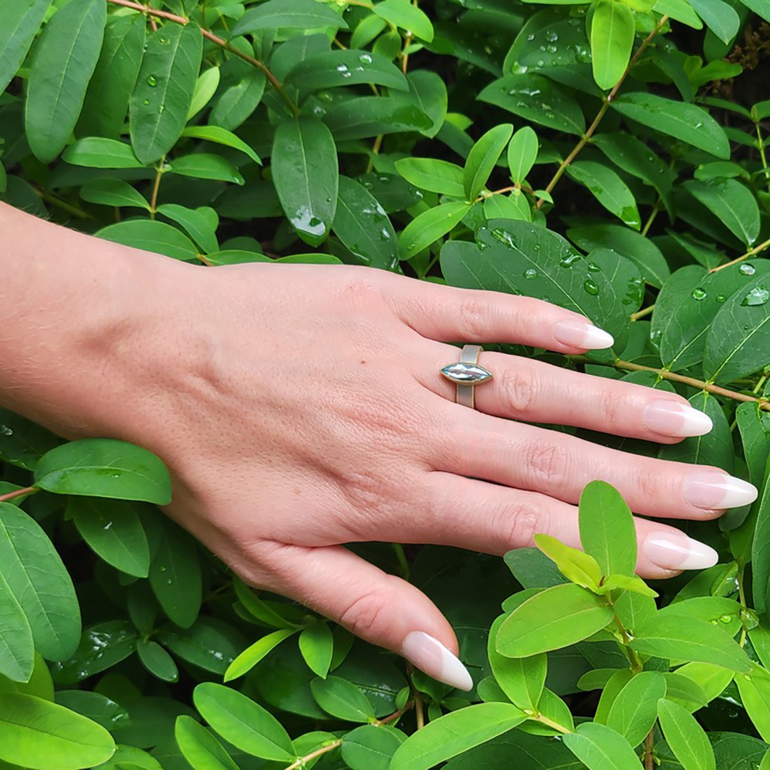 Marquis Aquamarine Ring. Aquamarine, silver, 14k yellow gold. Shown here on white female model. Handmade fine art jewelry by Rebecca Myers Design.
