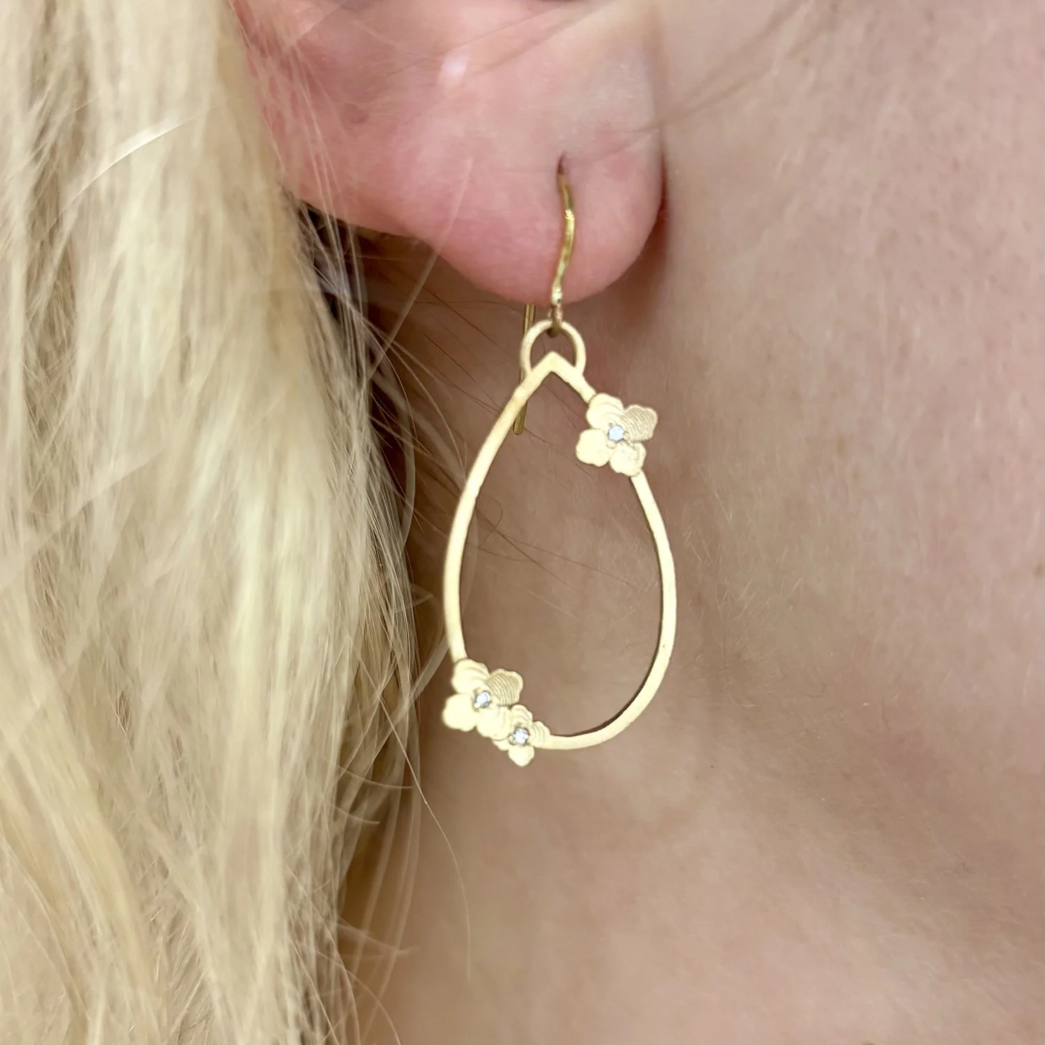 Gold Teardrop with Hydrangeas on white, female model. Handmade fine art jewelry by Rebecca Myers Design.