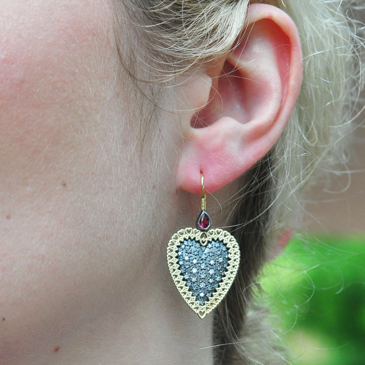 Large Framed Pave Heart EAS with Ruby Tops. 14k & 18k yellow gold, oxidized silver, pave set diamonds, rubies. Shown on white female model. Handmade fine art jewelry by Rebecca Myers Design.