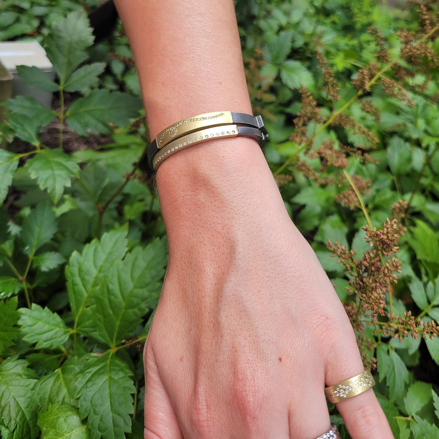 Looping Diamond Hinged Bracelet. 18k yellow gold, flush set diamonds, oxidized silver. Shown here on white female model. Handmade fine art jewelry by Rebecca Myers Design.