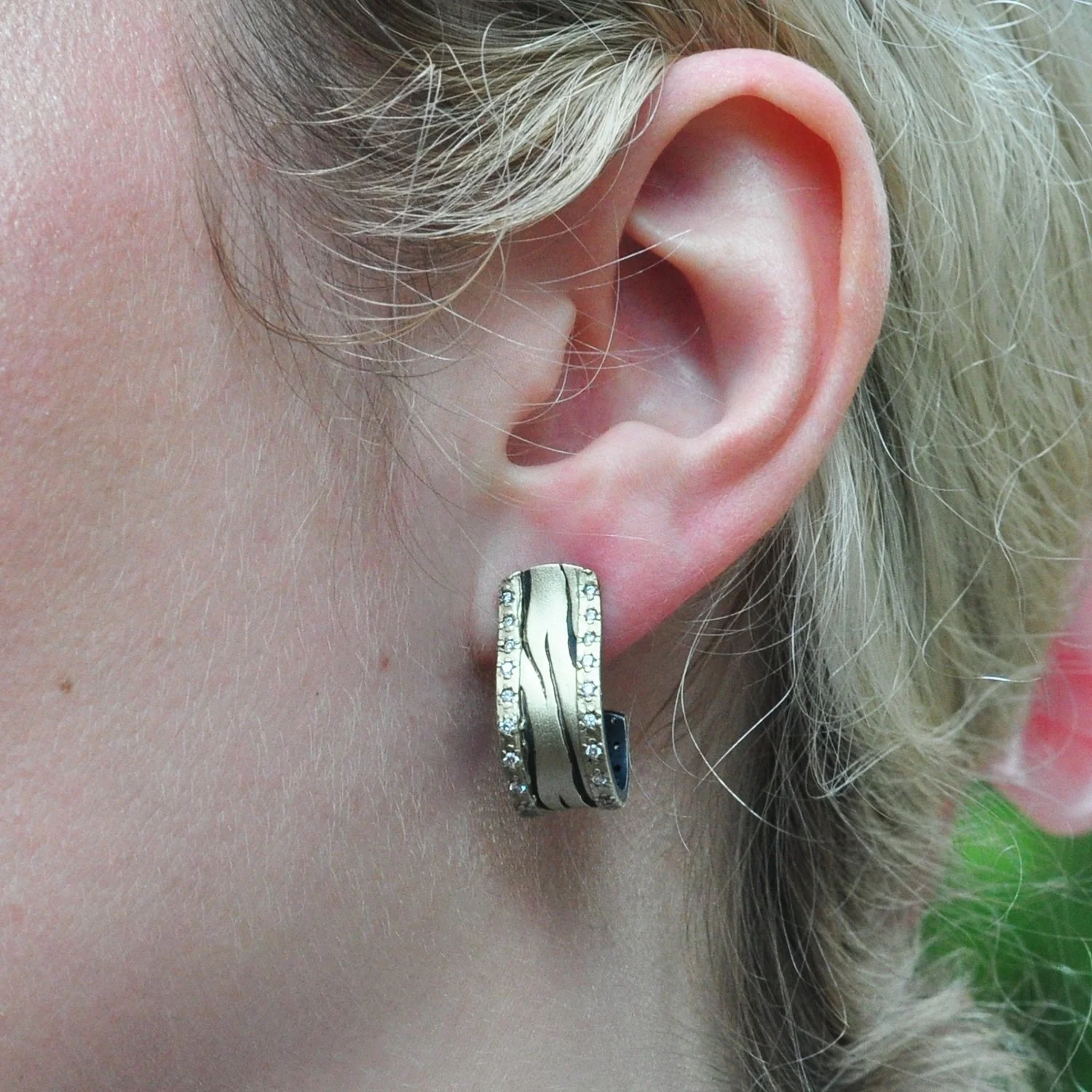 Tiger J-Hook Earrings. Oxidized silver, pave set diamonds, 14k yellow gold. Shown on white female model. Handmade fine art jewelry by Rebecca Myers Design.