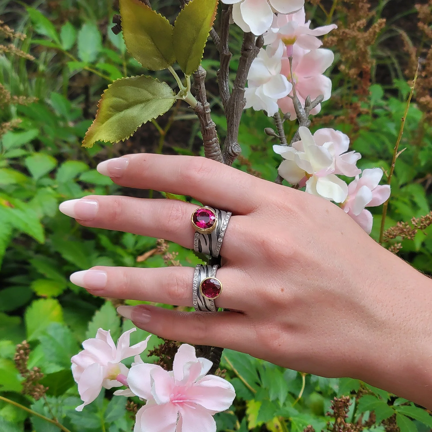 Zebra Print Rings with Pink Tourmaline. Platinum, oxidized silver, pave set diamonds, round faceted pink tourmaline. On white female model. Handmade fine art jewelry by Rebecca Myers Design.